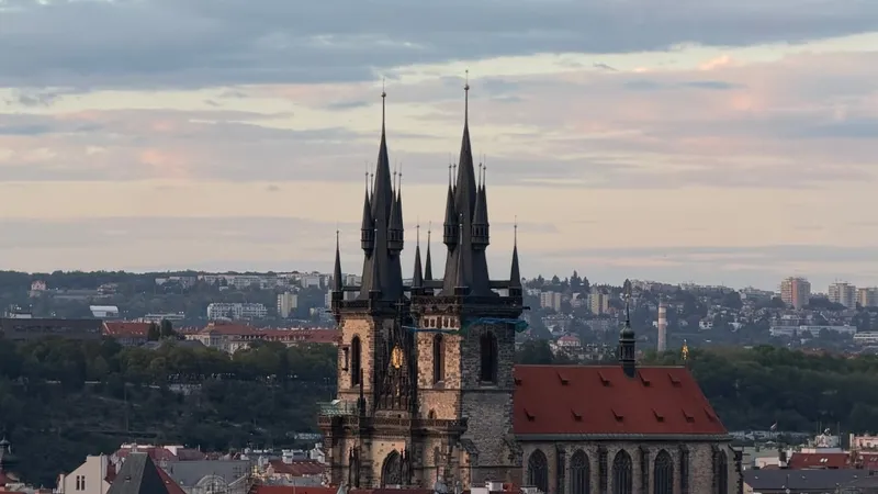 The Church of Our Lady before Tyn rising above the rooftops of Prague Old Town at dusk